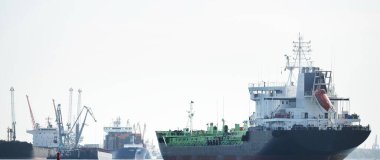 Büyük siyah tanker (kargo gemisi) limana yaklaşıyor, yakın plan. Riga Körfezi, Baltık Denizi, Letonya. Yük taşımacılığı, küresel iletişim, lojistik, çevresel hasar teması