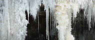 Donmuş Keila şelalesi, buz saçakları ve su sıçrıyor. Estonya 'da kış. Soyut doğal model, grafik kaynaklar, iklim değişikliği ve küresel ısınma kavramı, çevresel koruma