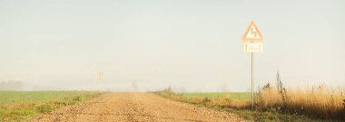 Eski bir köy asfalt yolu, sisli bir köyde. Sokak tabelası yakın plan. Açık mavi gökyüzü. Kırsal alan. Ulaşım, taşra, araba yolculuğu, araba kullanma. Sembol, kopyalama alanı, grafik kaynakları