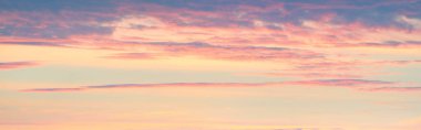 Clear blue sky with glowing pink and golden clouds. Dramatic cloudscape. Sunrise. Neon colors. Concept art, meteorology, heaven, hope, peace. Graphic resources, picturesque panoramic scenery