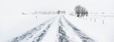 Kar fırtınası sonrasında kırsal alanlarda karla kaplı otoyol (asfalt yol). Laponya, Finlandiya. Tehlikeli sürüş, iklim değişikliği, küresel ısınma, ekoloji, çevre koruma