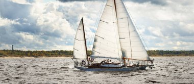 Eski pahalı, ahşap yelkenli (Ywl) yakın çekim, fırtınadan önce dramatik gökyüzü altında yelken. Yelkenli yat yarışı. Destansı bulut manzarası. Kiel, Kuzey Almanya