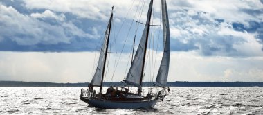 Eski pahalı, ahşap yelkenli (Ywl) yakın çekim, fırtınadan önce dramatik gökyüzü altında yelken. Yelkenli yat yarışı. Destansı bulut manzarası. Kiel, Kuzey Almanya