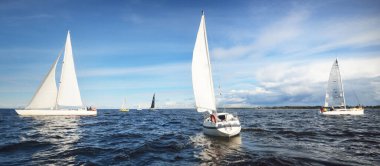 Yelkenli yat yarışı. Modern yelkenliler yakın plan. Fırtınadan sonra dramatik mavi gökyüzü. Muazzam bulut manzarası. Kuzey Almanya, Kiel