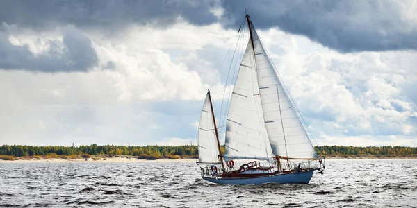 Eski pahalı, ahşap yelkenli (Ywl) yakın çekim, fırtınadan önce dramatik gökyüzü altında yelken. Yelkenli yat yarışı. Destansı bulut manzarası. Kiel, Kuzey Almanya