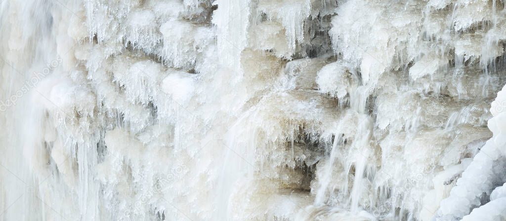 Frozen Keila waterfall, icicles and water splashes close-up. Winter in Estonia. Abstract natural pattern, graphic resources, climate change and global warming concept, environmental conservation