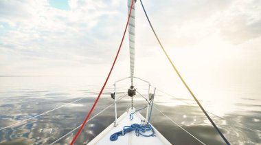 Gün batımında durgun suda yüzen beyaz bir yat. Güverteden pruvaya bir manzara, direk, yelkenler. Şaşırtıcı bulut manzarası. Sudaki yansımalar. Baltık Denizi. Yaşam tarzı, deniz yolculuğu, yelkenli yarışı, spor, eğlence