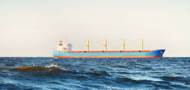 Large cargo ship sailing in the Baltic sea. Panoramic view from the sailing boat. Freight transportation, nautical vessel, logistics