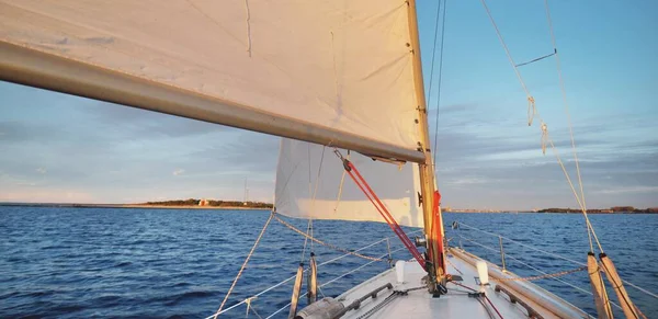 ホワイトスループは日没時にヨットを操縦した 嵐の後は快晴 デッキから弓 マスト 帆を表示します クルーズ スポーツ レクリエーション レジャー活動 レース — ストック写真