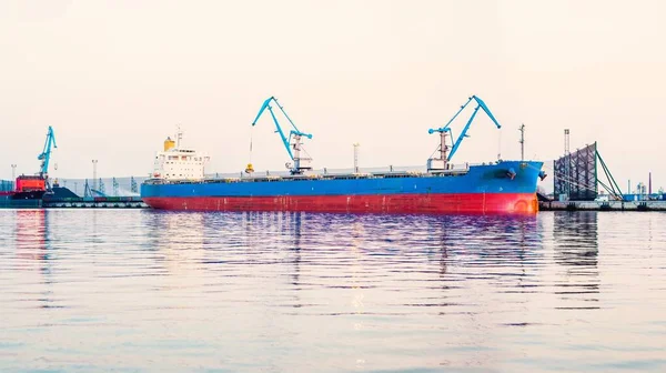 Large cargo ship loading in port terminal. Panoramic view. Freight transportation, nautical vessel, global communications, logistics, shipping, delivery, industry, commerce, economy