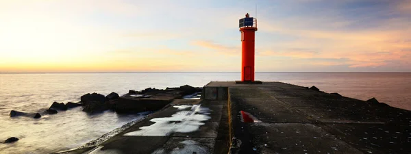 カラフルな夕日の空に対して太陽電池とオレンジの灯台への空の遊歩道 見事な雲景だ 長時間露光 環境保全のテーマ バルト海 リガ湾 ラトビア — ストック写真