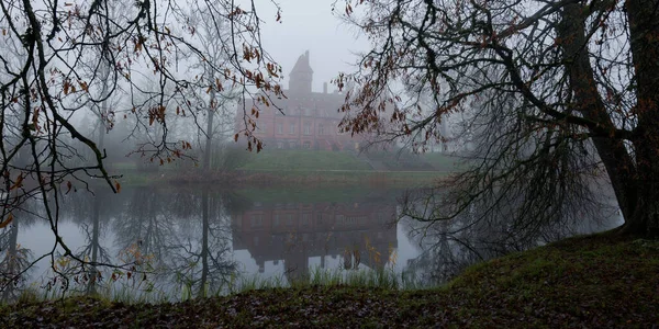 池塘和森林公园里的城堡拉脱维亚 Jaunmoku Pils 秋天的大气景观 忧郁的概念 全景视图 — 图库照片