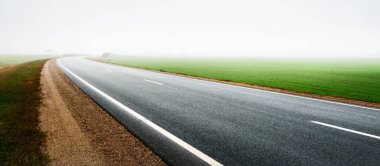 Tarla ve orman boyunca (yeni asfalt yolu) boş bir otoyol. Sis, yağmurlu bir gün. Atmosferik sonbahar manzarası. Yalnızlık, uzak yerler, tehlikeli sürüş konsepti