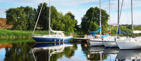 Элегантные и современные парусники пришвартованы к пристани для яхт. Отдых, транспорт, спорт, отдых, туризм, круизы, портовые услуги