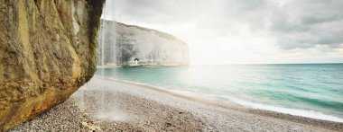 Gün batımında uçurum ve kayalık deniz kıyısında. Etretat, İngiliz kanalı, Normandiya, Fransa. Destansı renkli bulut manzarası. Ulusal dönüm noktası, seyahat yerleri, gezi teması. Uzun pozlama