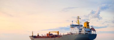 Büyük gri bir tanker gün batımında Europort 'tan denize açılacak. Renkli akşam bulutları. Rotterdam, Hollanda. Lojistik, ticaret, küresel iletişim teması