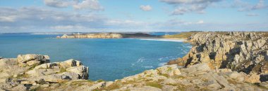 Pointe de Pen-Hir 'in kayalık sahili, uçurumlara yakın. Bulutlu mavi gökyüzü, masmavi su, fırtınalı dalgalar. Dramatik bulut manzarası. Crozon Yarımadası, Britanya, Fransa
