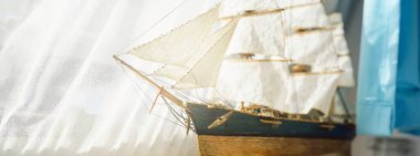 Zarif, ahşap, uzun bir gemi modeli. Klasik natürmort. Yelkencilik, seyahat, yön bulma kavramları. Koleksiyon, hatıra, hediye, oyuncak, retro stil, el yapımı, geleneksel zanaat