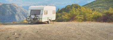 Lac de Serre-Poncon Gölü yakınlarındaki Fransız Alpleri manzaralı bir dağın tepesine park edilmiş karavan karavanı. Ulaşım, karavan, karavan, yol gezisi, kamp, turizm, eğlence, yaşam tarzı