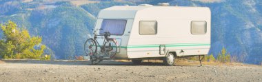 Lac de Serre-Poncon Gölü yakınlarındaki Fransız Alpleri manzaralı bir dağın tepesine park edilmiş karavan karavanı. Ulaşım, karavan, karavan, yol gezisi, kamp, turizm, eğlence, yaşam tarzı