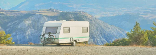 Lac de Serre-Poncon Gölü yakınlarındaki Fransız Alpleri manzaralı bir dağın tepesine park edilmiş karavan karavanı. Ulaşım, karavan, karavan, yol gezisi, kamp, turizm, eğlence, yaşam tarzı