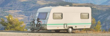 Lac de Serre-Poncon Gölü yakınlarındaki Fransız Alpleri manzaralı bir dağın tepesine park edilmiş karavan karavanı. Ulaşım, karavan, karavan, yol gezisi, kamp, turizm, eğlence, yaşam tarzı