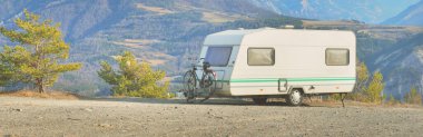 Lac de Serre-Poncon Gölü yakınlarındaki Fransız Alpleri manzaralı bir dağın tepesine park edilmiş karavan karavanı. Ulaşım, karavan, karavan, yol gezisi, kamp, turizm, eğlence, yaşam tarzı