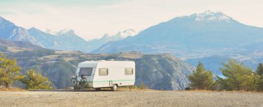 Lac de Serre-Poncon Gölü yakınlarındaki Fransız Alpleri manzaralı bir dağın tepesine park edilmiş karavan karavanı. Ulaşım, karavan, karavan, yol gezisi, kamp, turizm, eğlence, yaşam tarzı