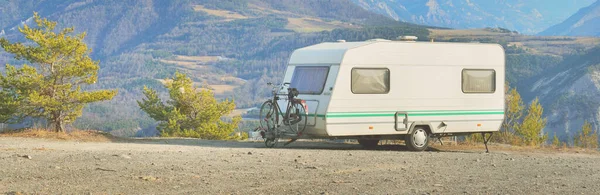 Lac de Serre-Poncon Gölü yakınlarındaki Fransız Alpleri manzaralı bir dağın tepesine park edilmiş karavan karavanı. Ulaşım, karavan, karavan, yol gezisi, kamp, turizm, eğlence, yaşam tarzı