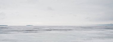 Bulutlu bir günde donmuş orman gölü. Kar fırtınasından sonra dramatik bir gökyüzü. Onega, Karelia, Rusya. Atmosferik kış manzarası. Panoramik manzara. Doğa, iklim değişikliği, Noel tatilleri, eko turizm