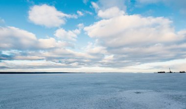 Bulutlu bir günde donmuş orman gölü. Kar fırtınasından sonra dramatik bir gökyüzü. Onega, Karelia, Rusya. Atmosferik kış manzarası. Panoramik manzara. Doğa, iklim değişikliği, Noel tatilleri, eko turizm