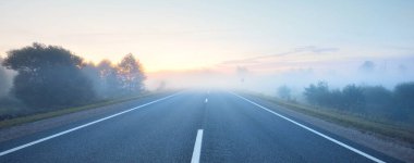 Sisin içinde açık bir otoyol. Gün doğumu. Kırsal alanlarda araba sürmek. Boş zaman aktivitesi, eğlence, ileriye dönük kavramlar.