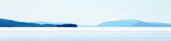 Mladé Borovice Zamrzlé Jezero Bouři Jasného Dne Horské Vrcholy Pozadí — Stock fotografie