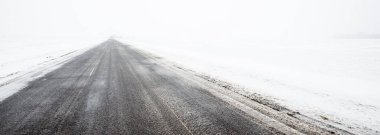 Kar fırtınası sırasında karla kaplı arazide köy yolu. Atmosferik kış manzarası. Buz Çölü