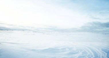 Gün batımında kar fırtınasından sonra karla kaplı arazinin panoramik görüntüsü. Taze karda insan izleri. Buz çölü. Dramatik bulut manzarası. Küresel ısınma teması. Laponya, Finlandiya