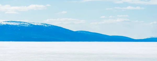 Mladé Borovice Zamrzlé Jezero Bouři Jasného Dne Horské Vrcholy Pozadí — Stock fotografie