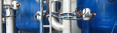 Büyük endüstriyel su arıtma ve kazan dairesi. Parlak çelik borular, mavi pompalar ve vanalar. Sanayi, teknoloji, kimya, ısıtma, iş güvenliği, teçhizat, arz, altyapı