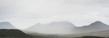 Dağlar, karanlık fırtına gökyüzünün altında zirve yapar. Dramatik bulutlar. Jura Adası, Inner Hebrides, İskoçya, İngiltere. Atmosferik manzara. Panoramik görünüm