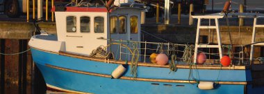 Yat limanındaki bir rıhtıma demirlemiş bir balıkçı teknesi. Port Ellen, Islay Adası, Inner Hebrides, İskoçya, İngiltere. Ulaşım, geleneksel zanaat, sanayi