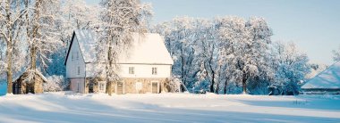 Güneşli bir günde kırsal kesimde Alman tarzı sıcacık kır evi olan kış manzarası. Geleneksel mimari, seyahat merkezleri, Noel tatilleri, eko-turizm, uzak yerler