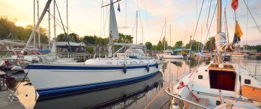 Zarif ve modern yelkenliler (kiralık) açık bir günde bir yatla iskeleye demirlediler. Ulaşım, gezi, boş zaman aktivitesi, spor ve eğlence teması. İsveç