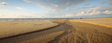 Destansı kümülüs bulutları, fırtınadan sonra kumlu Baltık deniz kıyısında. Kuru nehir, yakın çekim kum dokusu. - Letonya. Dramatik bir gökyüzü. Ekoloji, çevre koruma, kararsız hava, iklim değişikliği