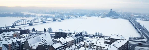 在一个清澈的冬日 从圣彼得教堂俯瞰里加古城和多加瓦河全景 铁路和公路桥 公共图书馆 积雪覆盖的房子 拉脱维亚 — 图库照片