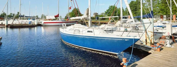 Zarif ve modern yelkenliler (kiralık) açık bir günde bir yatla iskeleye demirlediler. Ulaşım, gezi, boş zaman aktivitesi, spor ve eğlence teması. İsveç