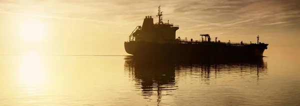 外洋を航行する大型貨物船 黄金の夕日の光 雲の風景 貨物輸送 グローバル通信 ビジネス 世界的な出荷 — ストック写真
