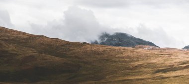 Dağlar, karanlık fırtına gökyüzünün altında zirve yapar. Dramatik bulutlar. Jura Adası, Inner Hebrides, İskoçya, İngiltere. Atmosferik manzara. Panoramik görünüm