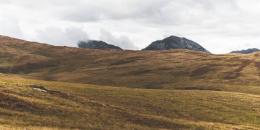 Dağlar, karanlık fırtına gökyüzünün altında zirve yapar. Dramatik bulutlar. Jura Adası, Inner Hebrides, İskoçya, İngiltere. Atmosferik manzara. Panoramik görünüm