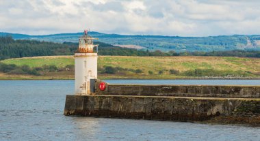 Eski deniz fenerine doğru boş bir gezinti, yakın plan. Arka planda kayalık kıyılar var. Dramatik bulut manzarası. Ardrishaig, Crinan Kanalı, İskoçya, İngiltere. Seyahat yerleri, gezi teması