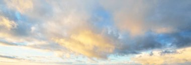 Açık mavi gökyüzü. Pembe ve altın rengi sirrus ve kümülüs bulutları fırtına üstüne, yumuşak güneş ışığı. Dramatik gün batımı bulutları. Meteoroloji, cennet, barış, grafik kaynakları, pitoresk panoramik manzara