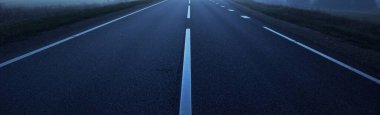 Geceleri boş bir asfalt yolu (karayolu). Panoramik görüntü. Karanlık manzara. Tehlikeli sürüş, hız, özgürlük, seyahat tutkusu, yol kavramları